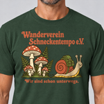 Nahaufnahme des Drucks: Wanderverein Schneckentempo – T-Shirt Unisex in Flaschengrün, von einem Mann getragen