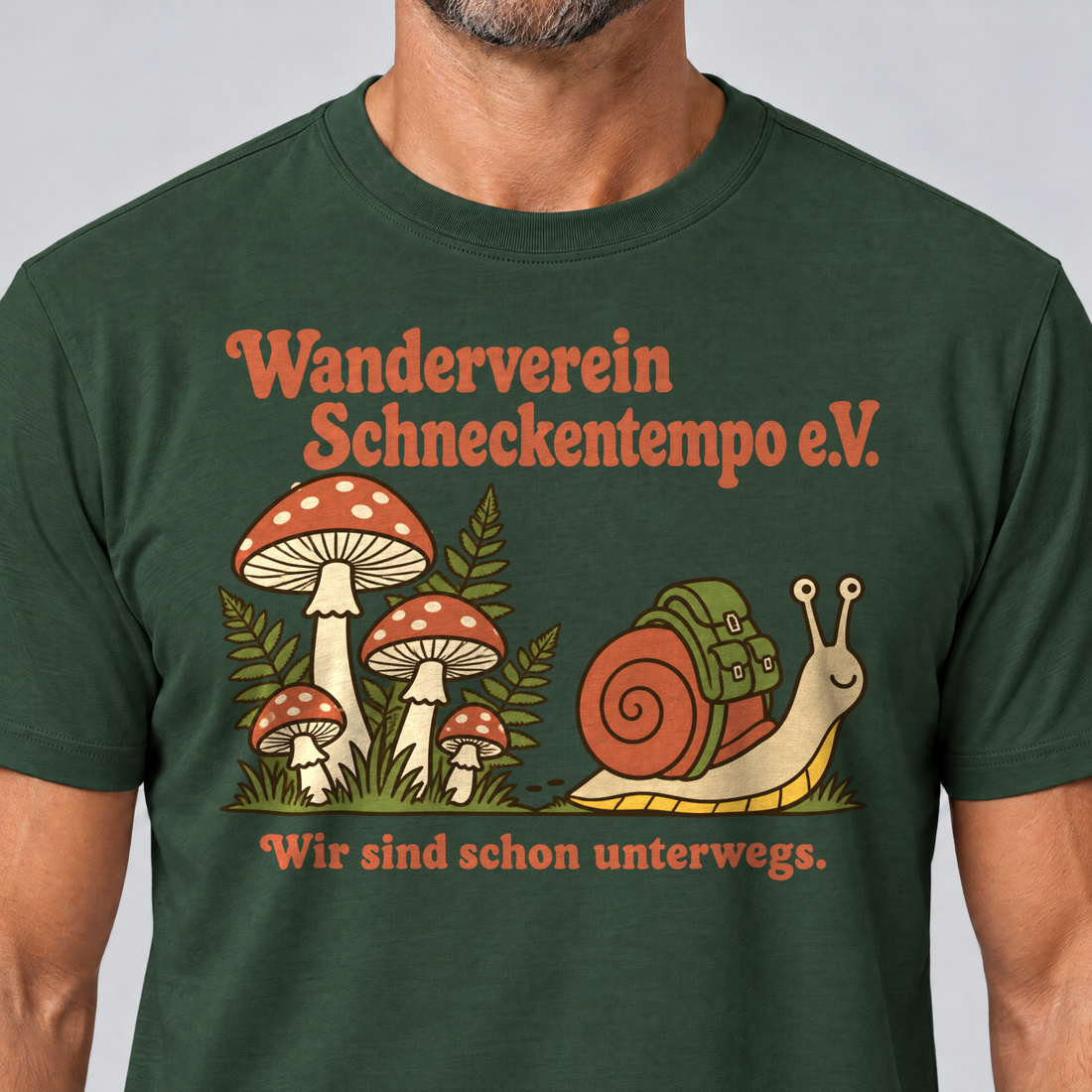 Nahaufnahme des Drucks: Wanderverein Schneckentempo – T-Shirt Unisex in Flaschengrün, von einem Mann getragen