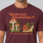 Nahaufnahme des Drucks: Wanderverein Schneckentempo – T-Shirt Unisex in Bordeaux, von einem Mann getragen