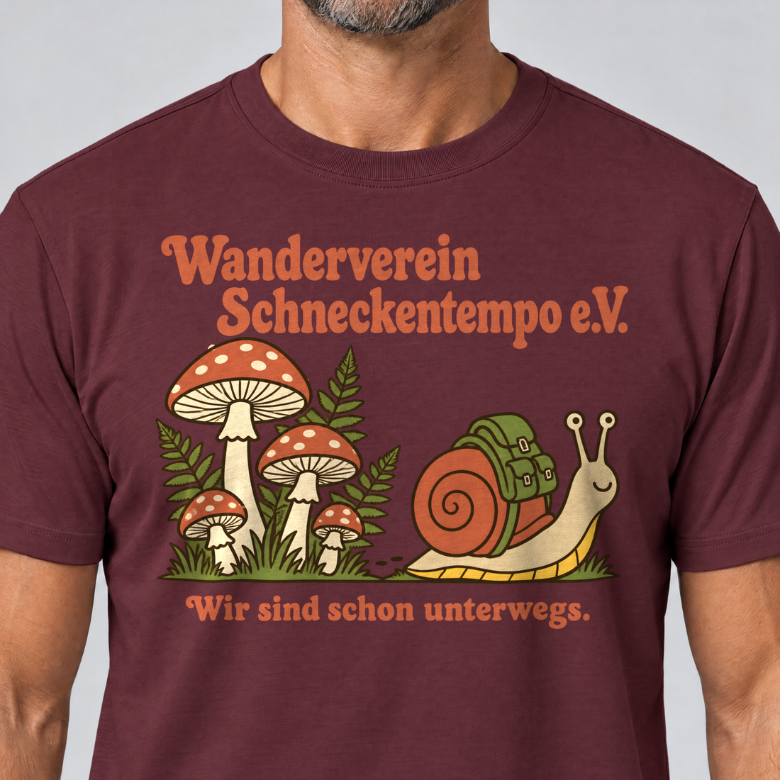 Nahaufnahme des Drucks: Wanderverein Schneckentempo – T-Shirt Unisex in Bordeaux, von einem Mann getragen