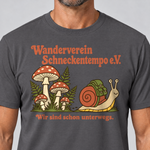 Nahaufnahme des Drucks: Wanderverein Schneckentempo – T-Shirt Unisex in Dunkelgrau, von einem Mann getragen