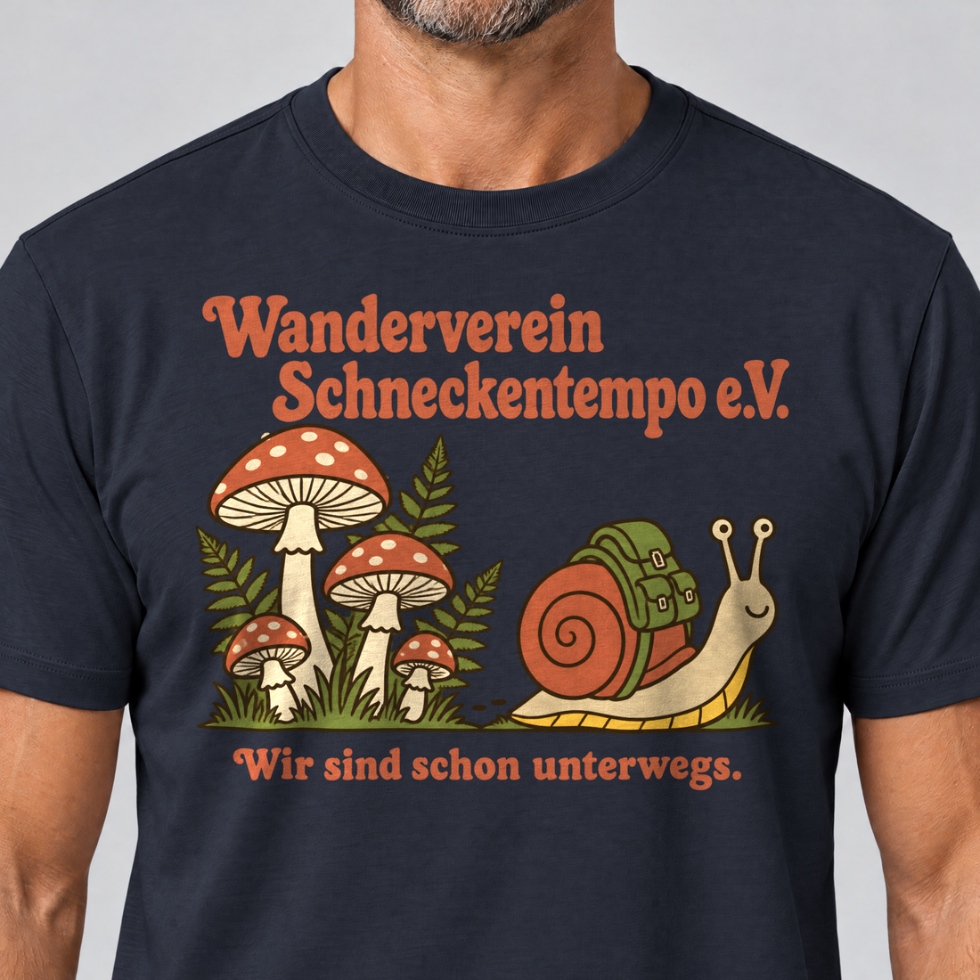 Nahaufnahme des Drucks: Wanderverein Schneckentempo – T-Shirt Unisex in Navy, von einem Mann getragen