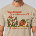 Nahaufnahme des Drucks: Wanderverein Schneckentempo – T-Shirt Unisex in Sand, von einem Mann getragen