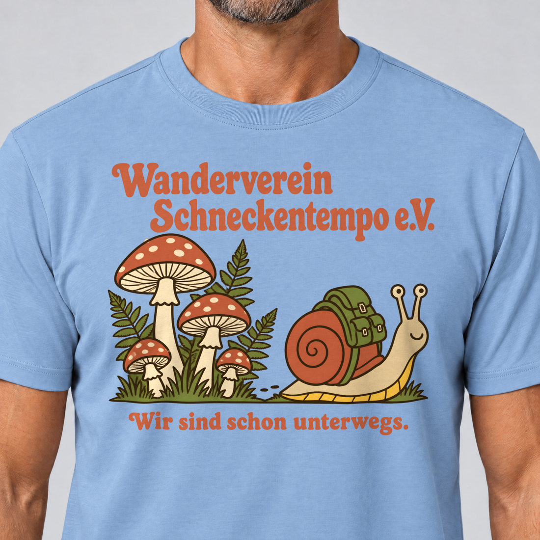 Nahaufnahme des Drucks: Wanderverein Schneckentempo – T-Shirt Unisex in Himmelblau, von einem Mann getragen
