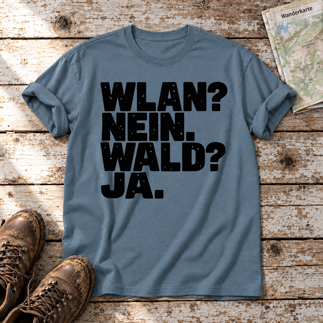 WLAN? Nein. Wald? Ja. – T-Shirt Unisex in Steinblau, flach liegend auf alten Holzbrettern mit Wanderschuhen und Wanderkarte.