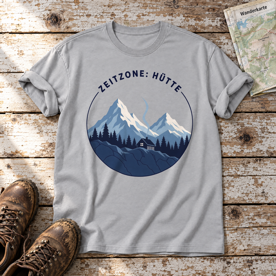 Zeitzone: Hütte – T-Shirt Unisex in Hellgrau, flach liegend auf alten Holzbrettern mit Wanderschuhen und Wanderkarte.