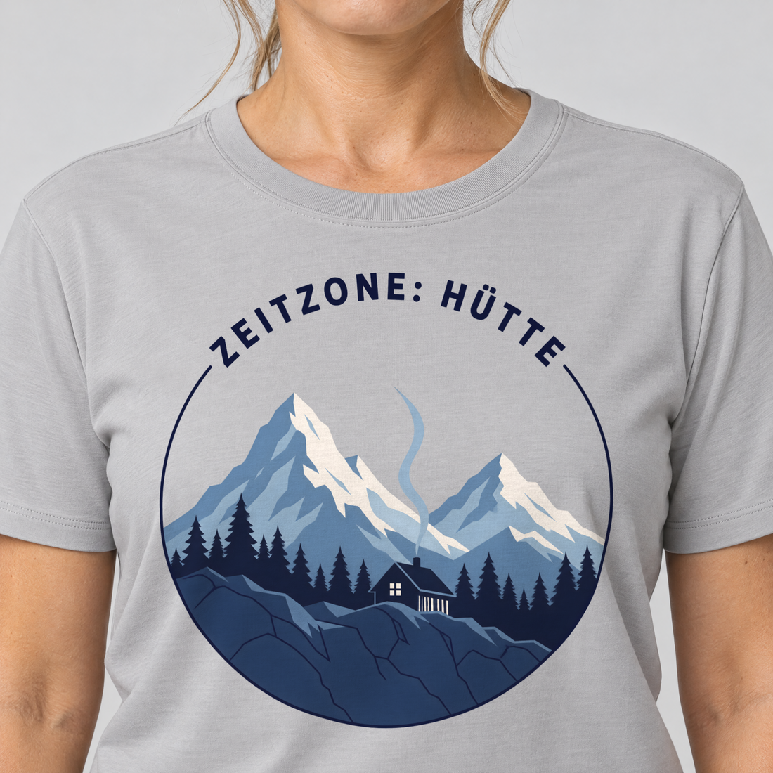 Nahaufnahme des Drucks: Zeitzone: Hütte – T-Shirt Unisex in Hellgrau, von einer Frau getragen