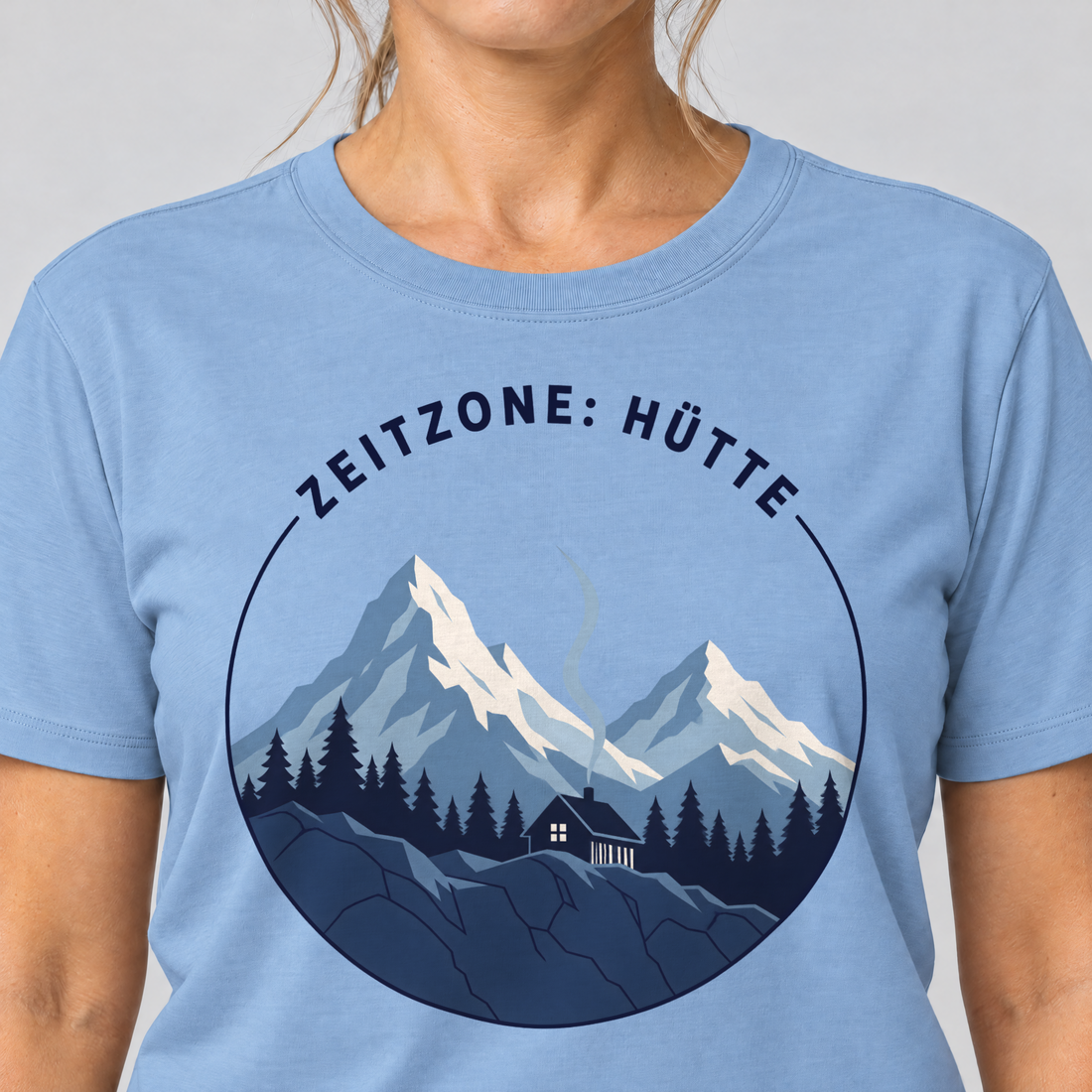 Nahaufnahme des Drucks: Zeitzone: Hütte – T-Shirt Unisex in Himmelblau, von einer Frau getragen
