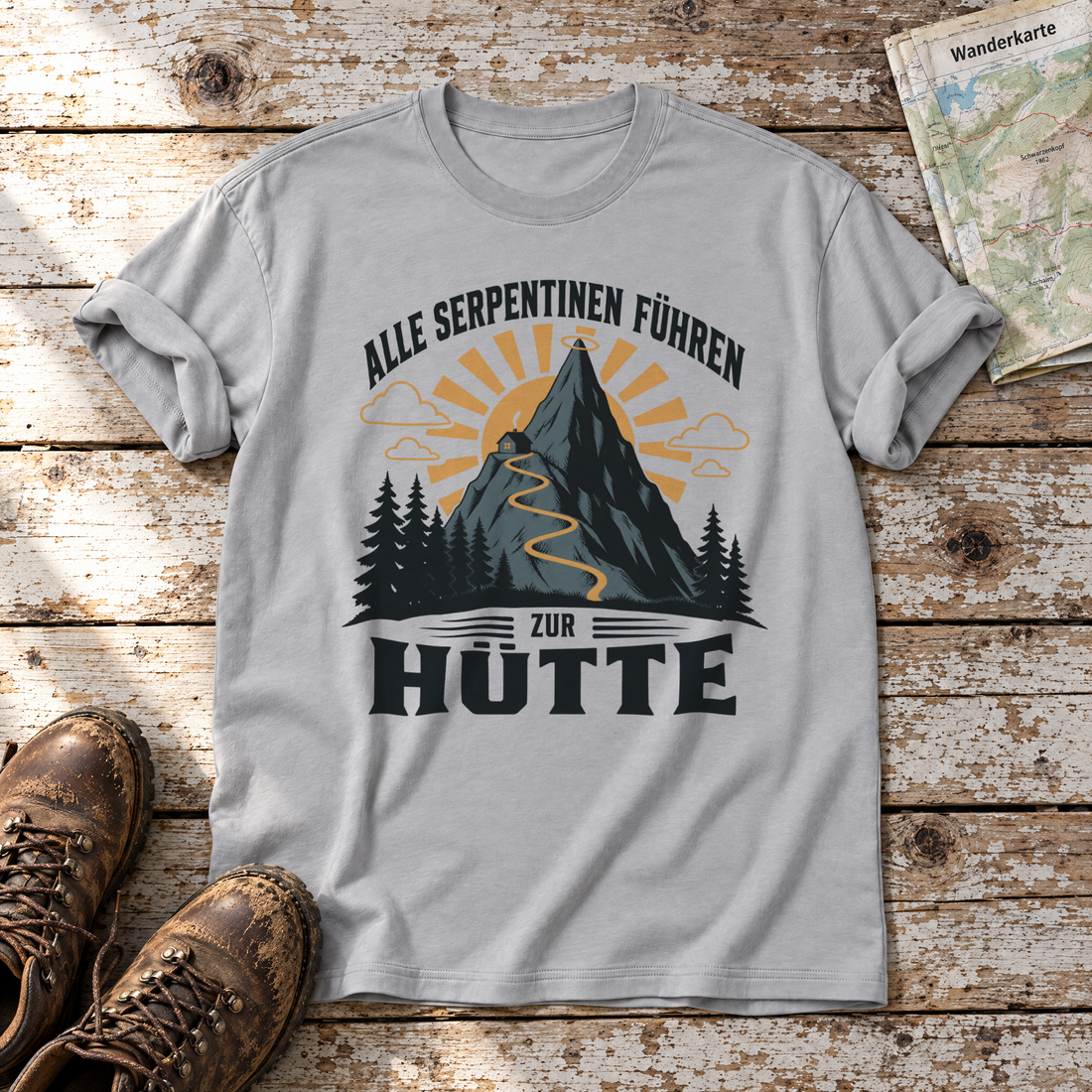 Alle Serpentinen führen zur Hütte – T-Shirt Unisex in Hellgrau, flach liegend auf alten Holzbrettern mit Wanderschuhen und Wanderkarte.