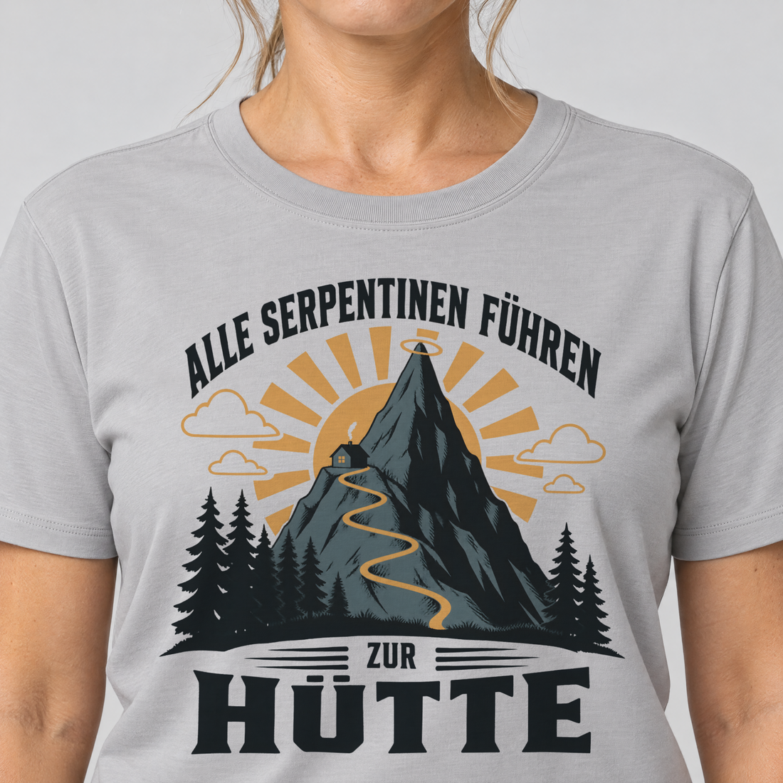 Nahaufnahme des Drucks: Alle Serpentinen führen zur Hütte – T-Shirt Unisex in Hellgrau, von einer Frau getragen