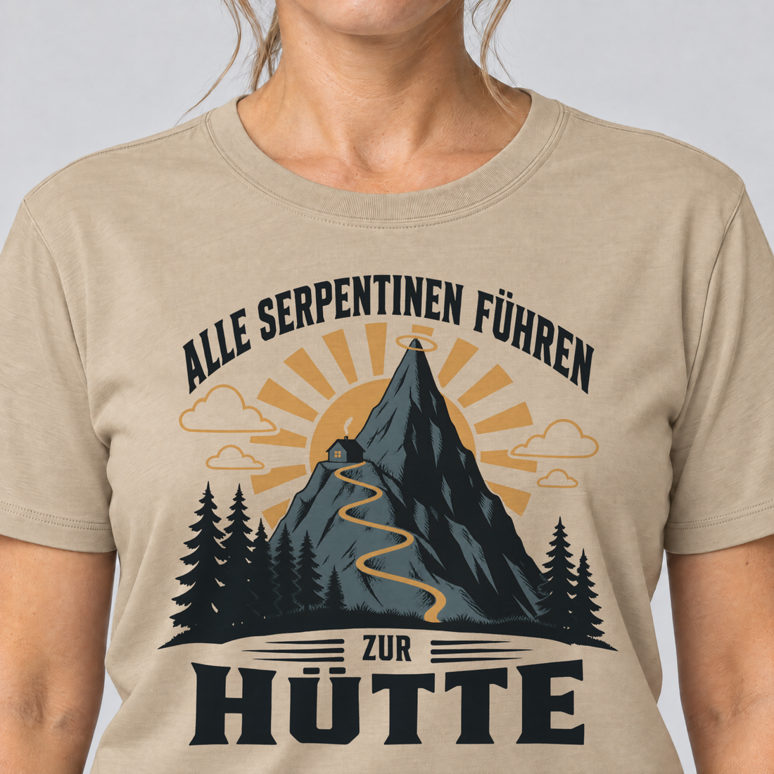 Nahaufnahme des Drucks: Alle Serpentinen führen zur Hütte – T-Shirt Unisex in Sand, von einer Frau getragen