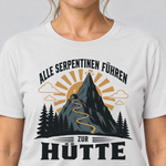 Nahaufnahme des Drucks: Alle Serpentinen führen zur Hütte – T-Shirt Unisex in Weiß, von einer Frau getragen
