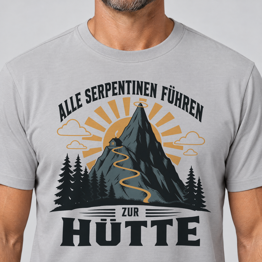 Nahaufnahme des Drucks: Alle Serpentinen führen zur Hütte – T-Shirt Unisex in Hellgrau, von einem Mann getragen